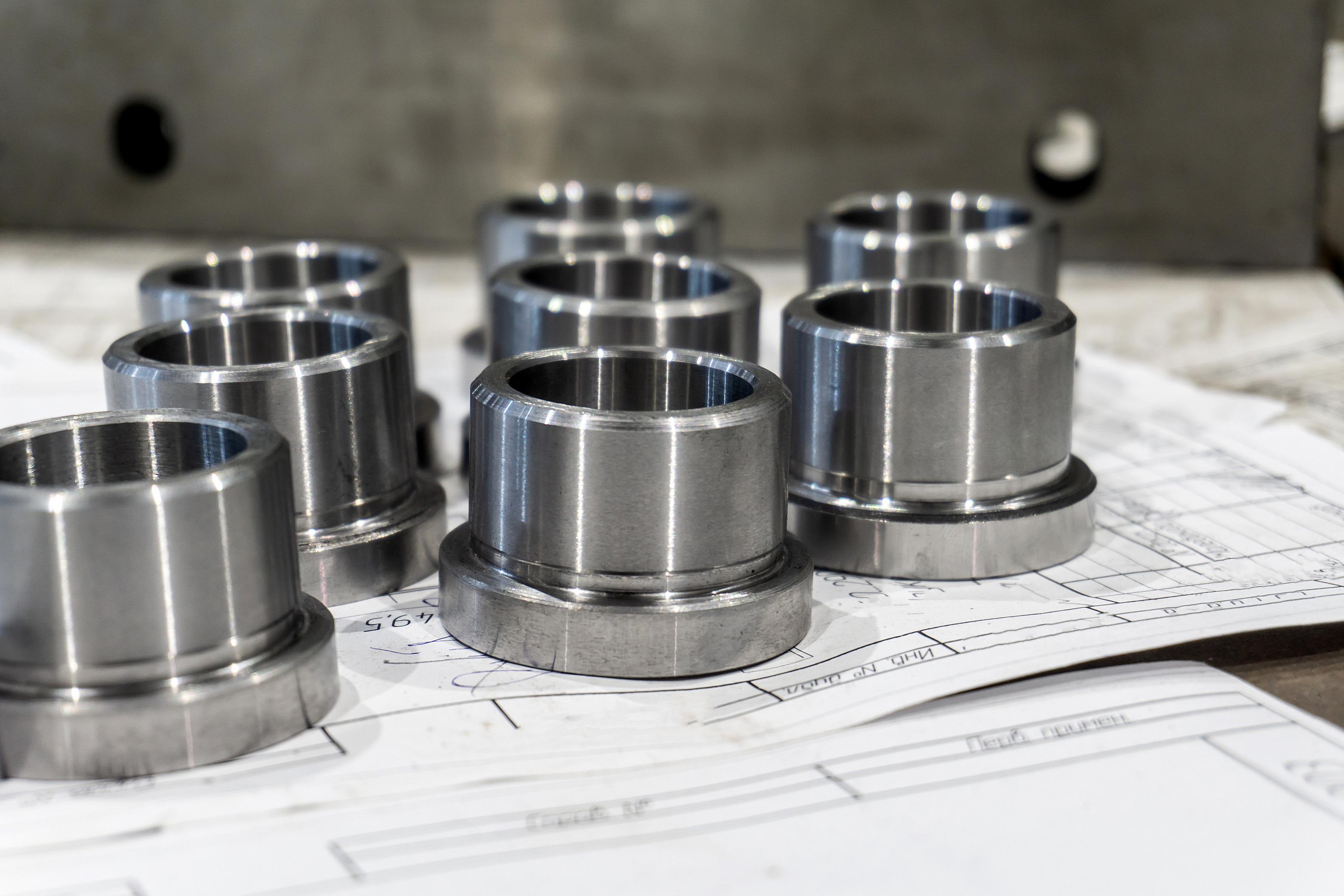 Machined metal components resting on an engineering drawing